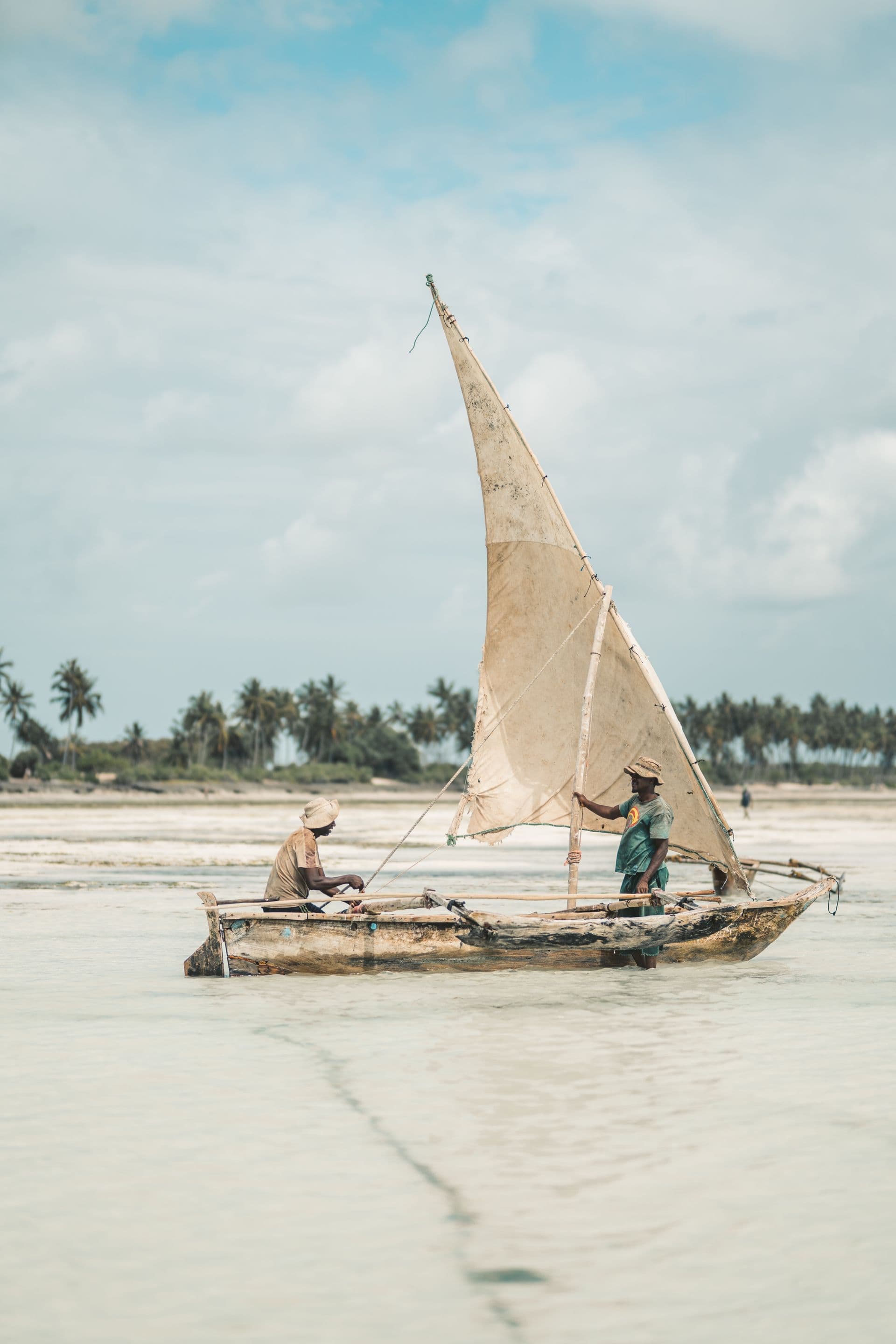 Traditional sailing boat resting on a white sand beach